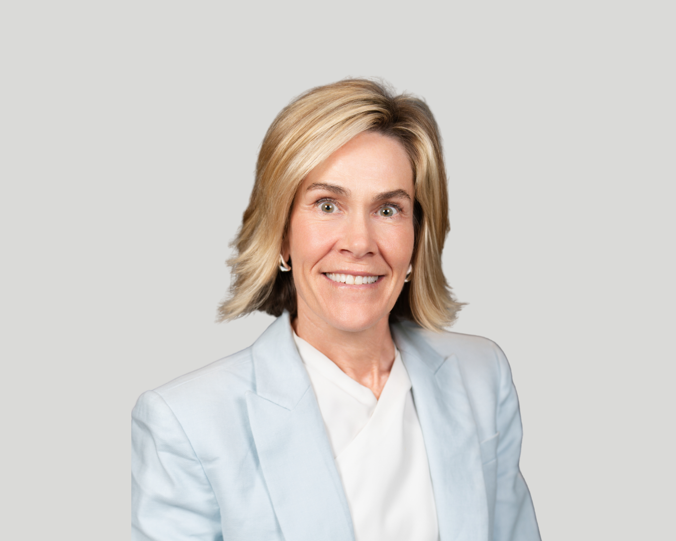 Cathy Hartman, white, blonde woman wearing pale blue blazer and white blouse headshot